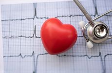 Red heart and stethoscope on electrocardiogram report